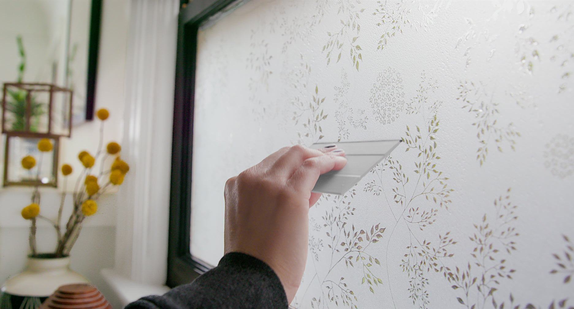 Load video: Window with window film on bottom pane and dried grasses displayed on both sides.