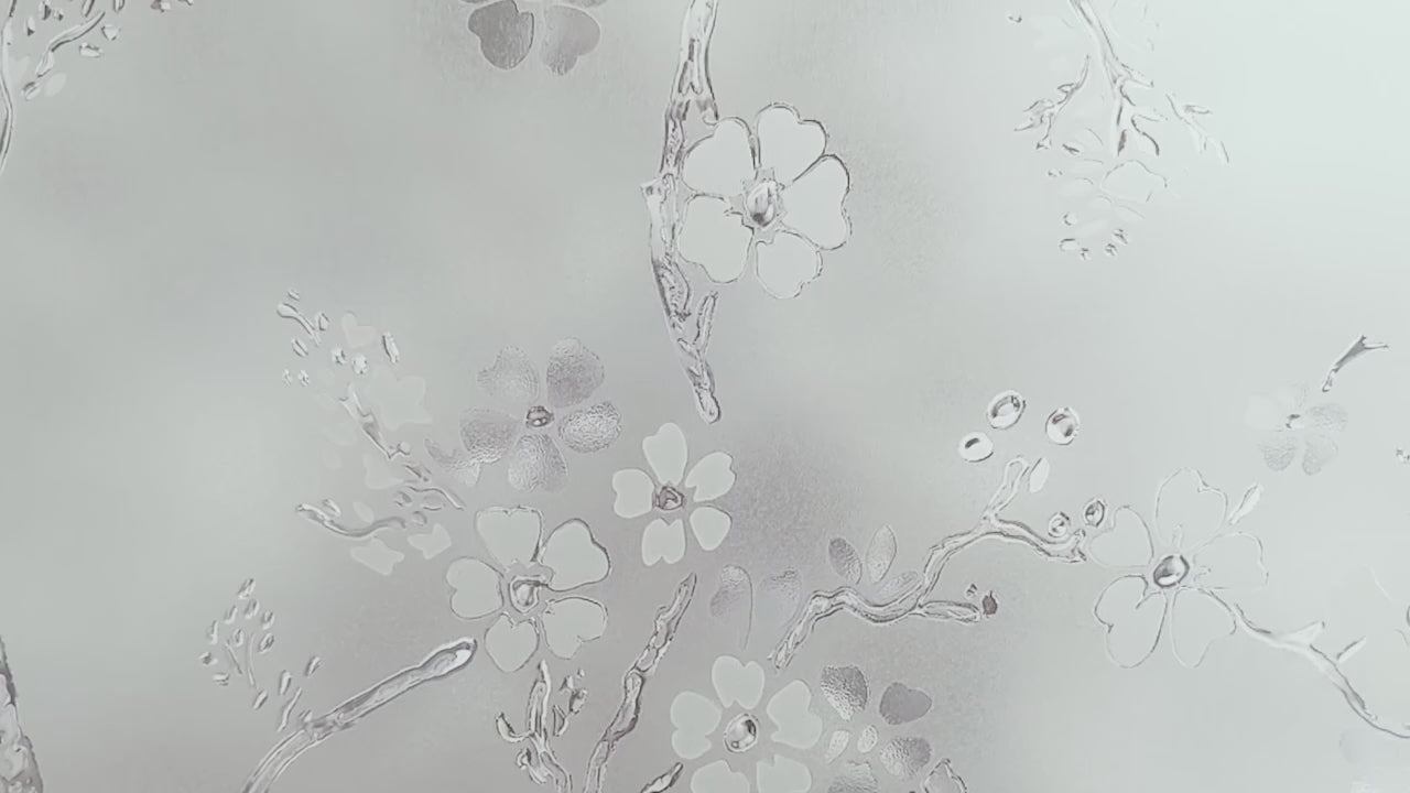 Video  moving over close-up of Artscape Blossom Decorative Privacy Window Film showing delicate pattern of spring blooming.